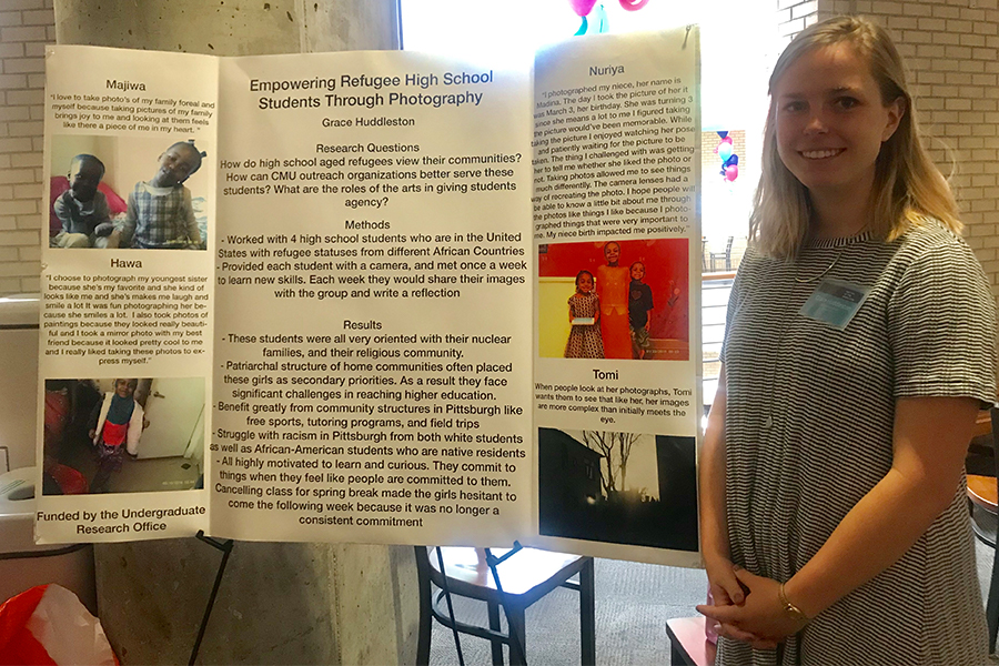 Grace Huddleston with the poster for her project, “Empowering Refugee High School Students Through Photography.”