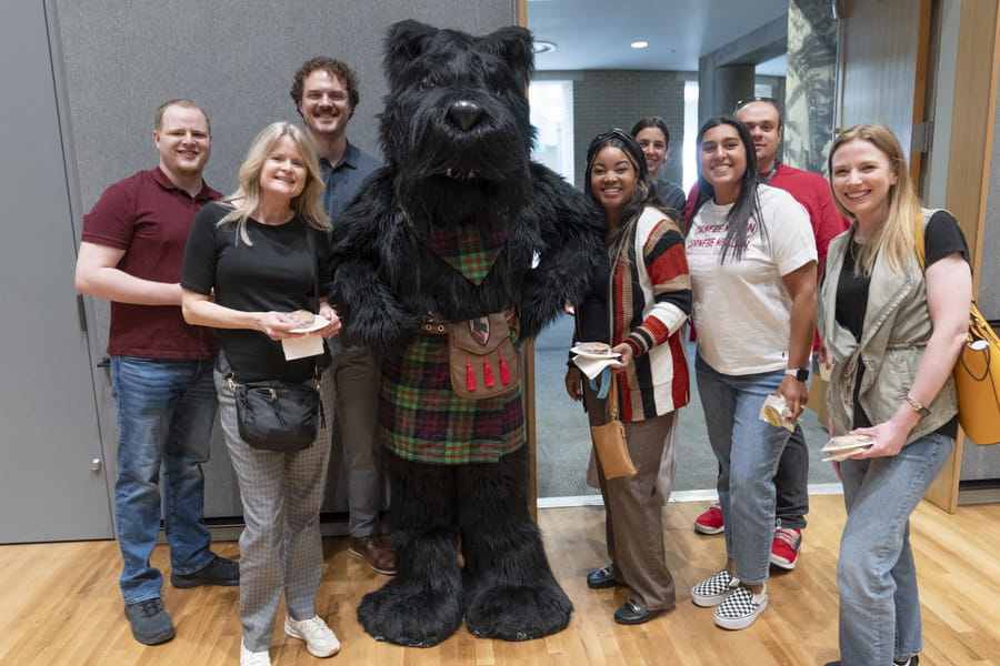 Group of CMU employees posing with CMU's Scotty Dog mascot