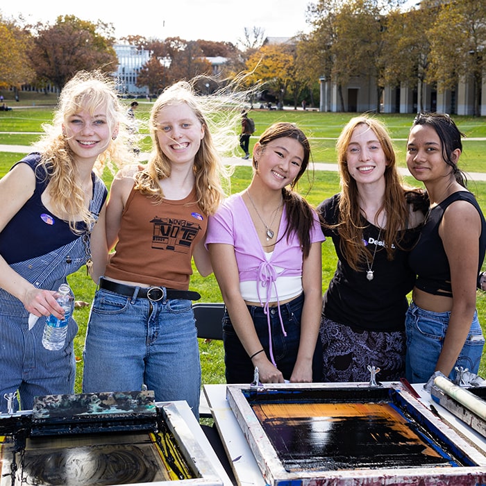 Students pause from screen-printing tote bags on the Cut for Democracy Day 2024.