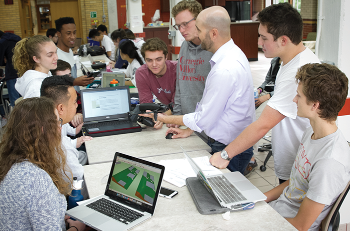 group of students discuss drone project with professor 