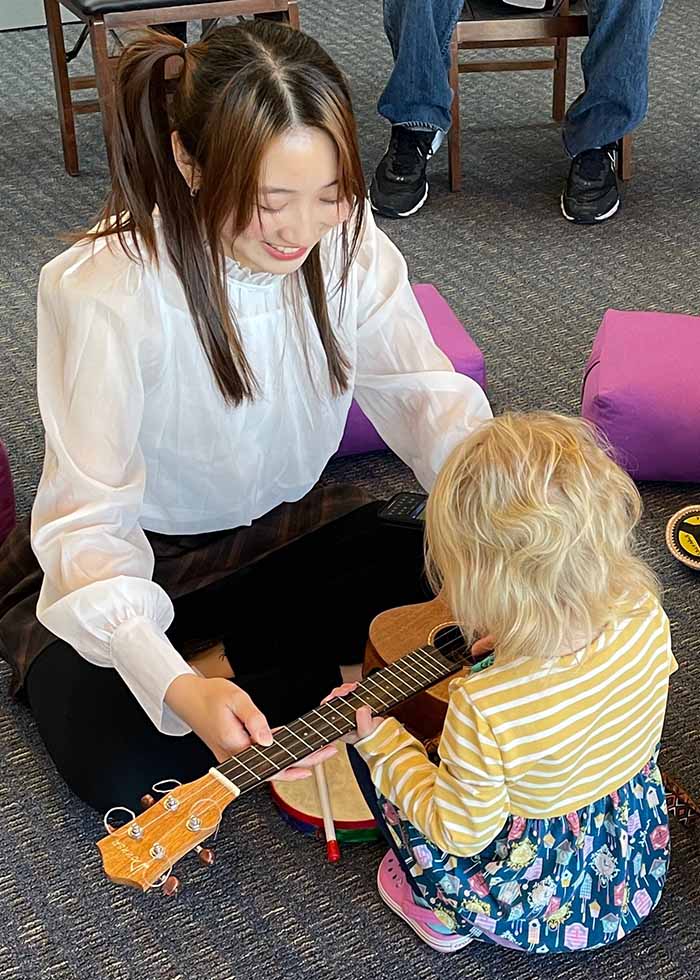 Photo of a student playing with a young child.