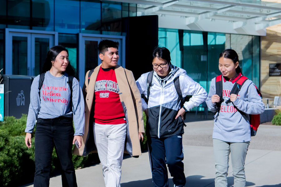 CMU students wearing CMU cloths walking in front of the Tepper building