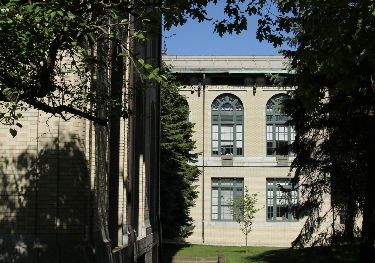 Baker Hall surrounded by tree canopy in the summer