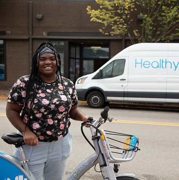 Dietrich undergraduate participating in an internship poses with a bicycle.