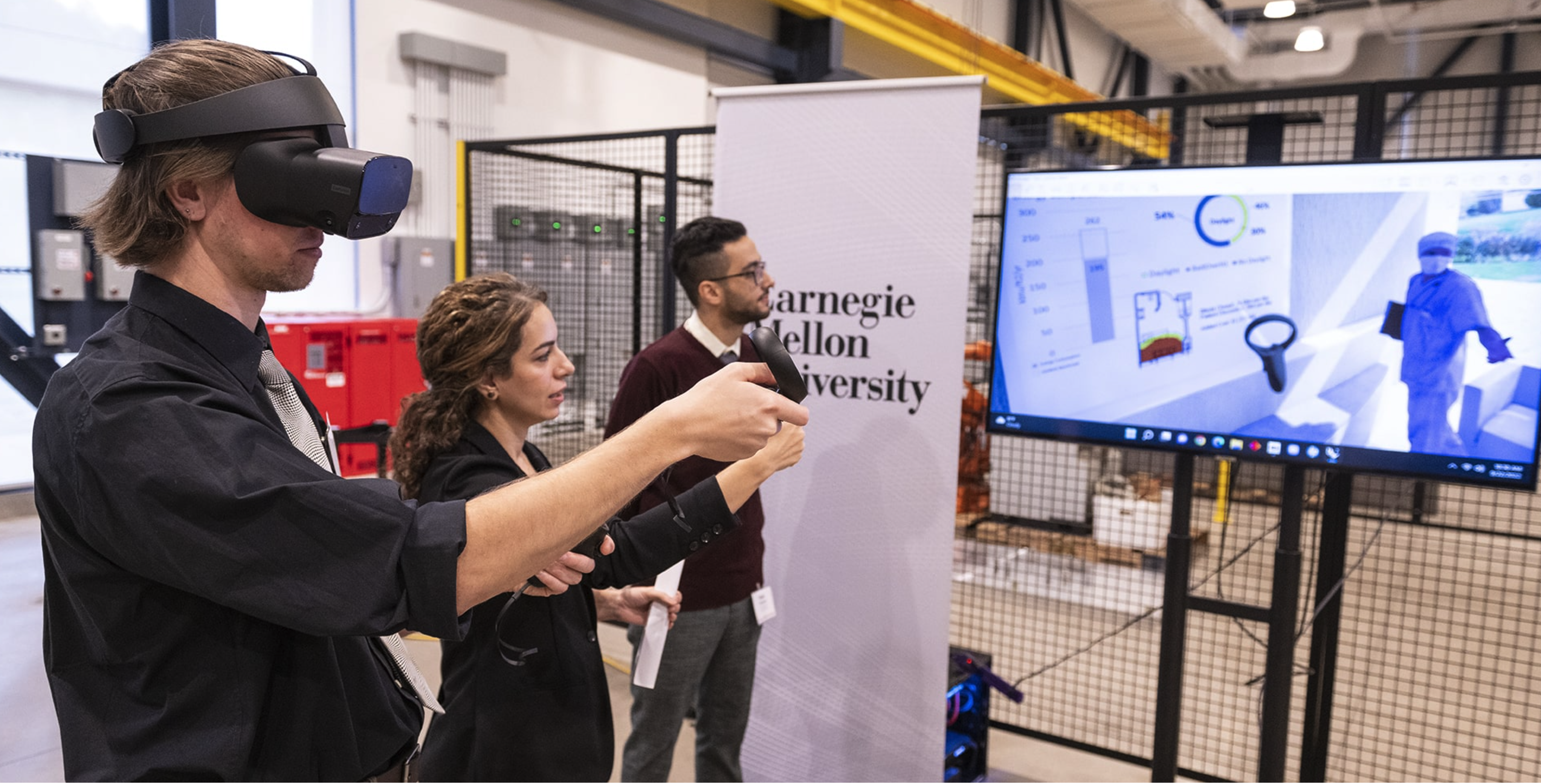 Azadeh Sawyer, center, assistant professor in building technology, gives a virtual reality tour at Mill 19 for green energy construction with the help of School of Architecture graduate students Mohammad Reza Takallouie, right, and Gavin Hurley, left.