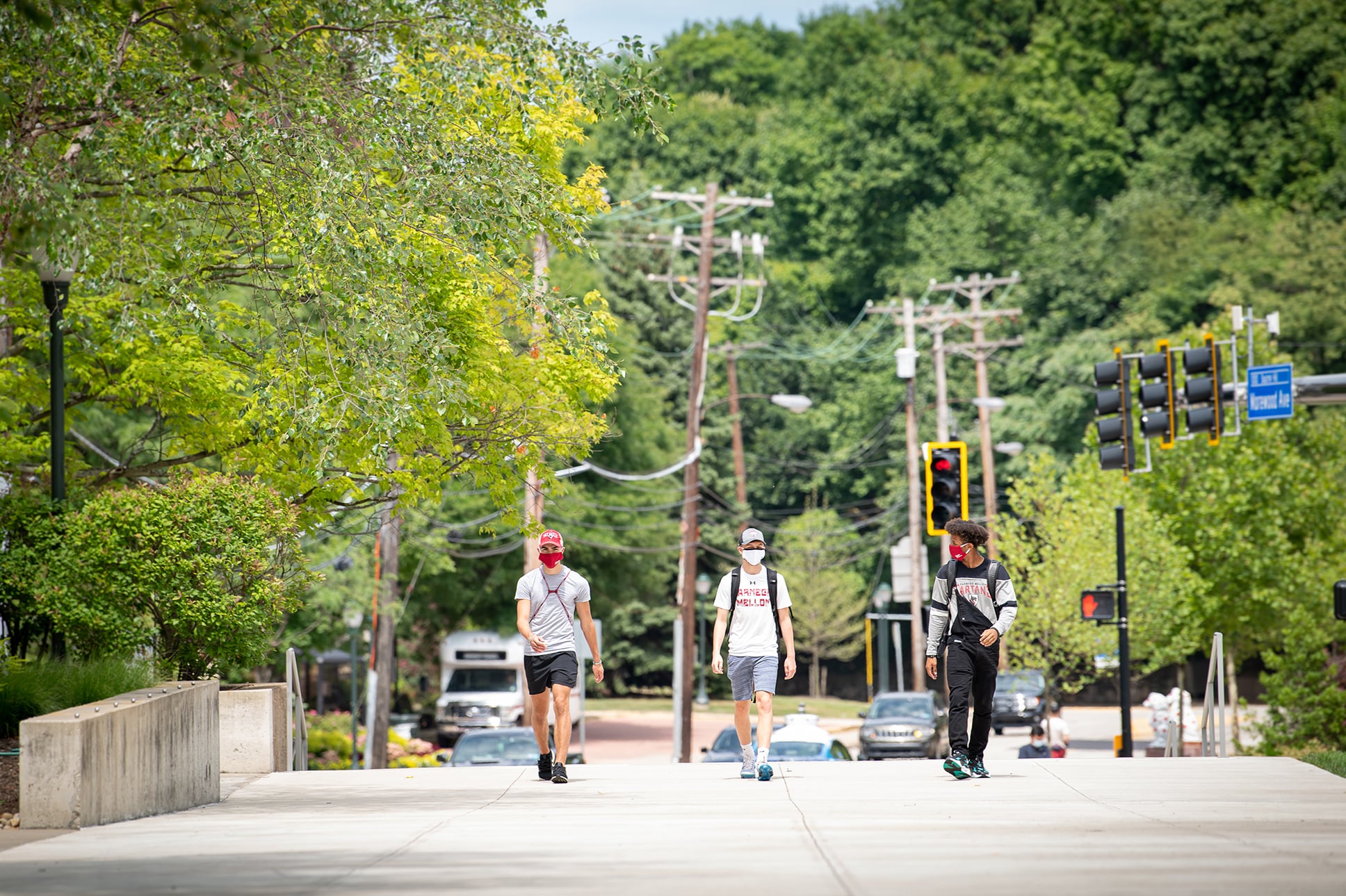 Three CMU students wearing facial coverings and physically distancing themselves