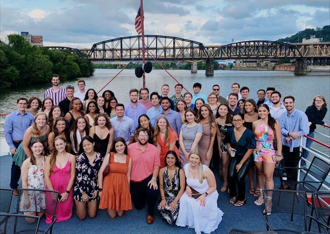 student trishala pillai is photographed with fellow interns from Dick's Sporting Goods on the deck of a boat on the Monongahela River in Pittsburgh
