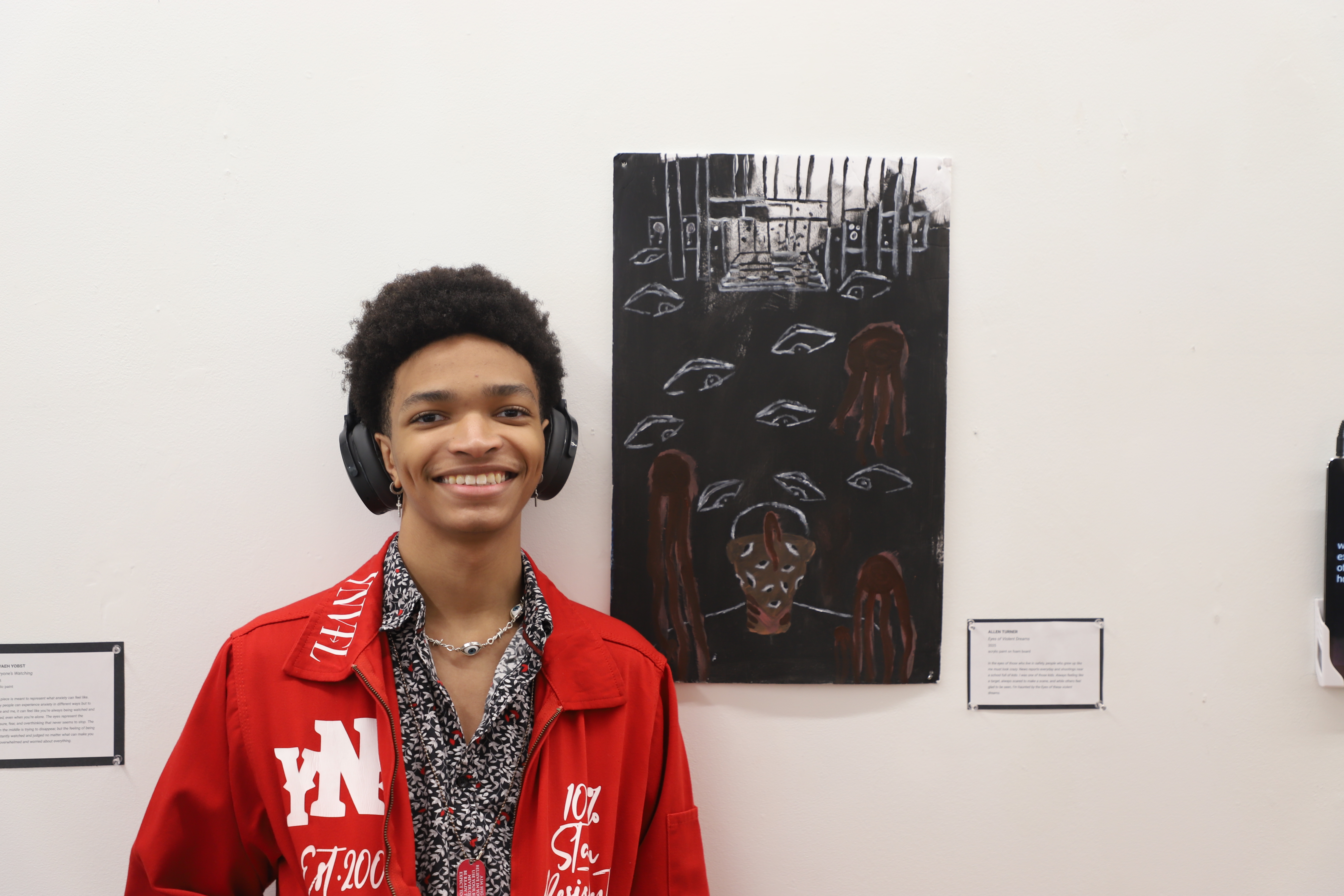 LEAP student Allen standing next to an acrylic painting he created