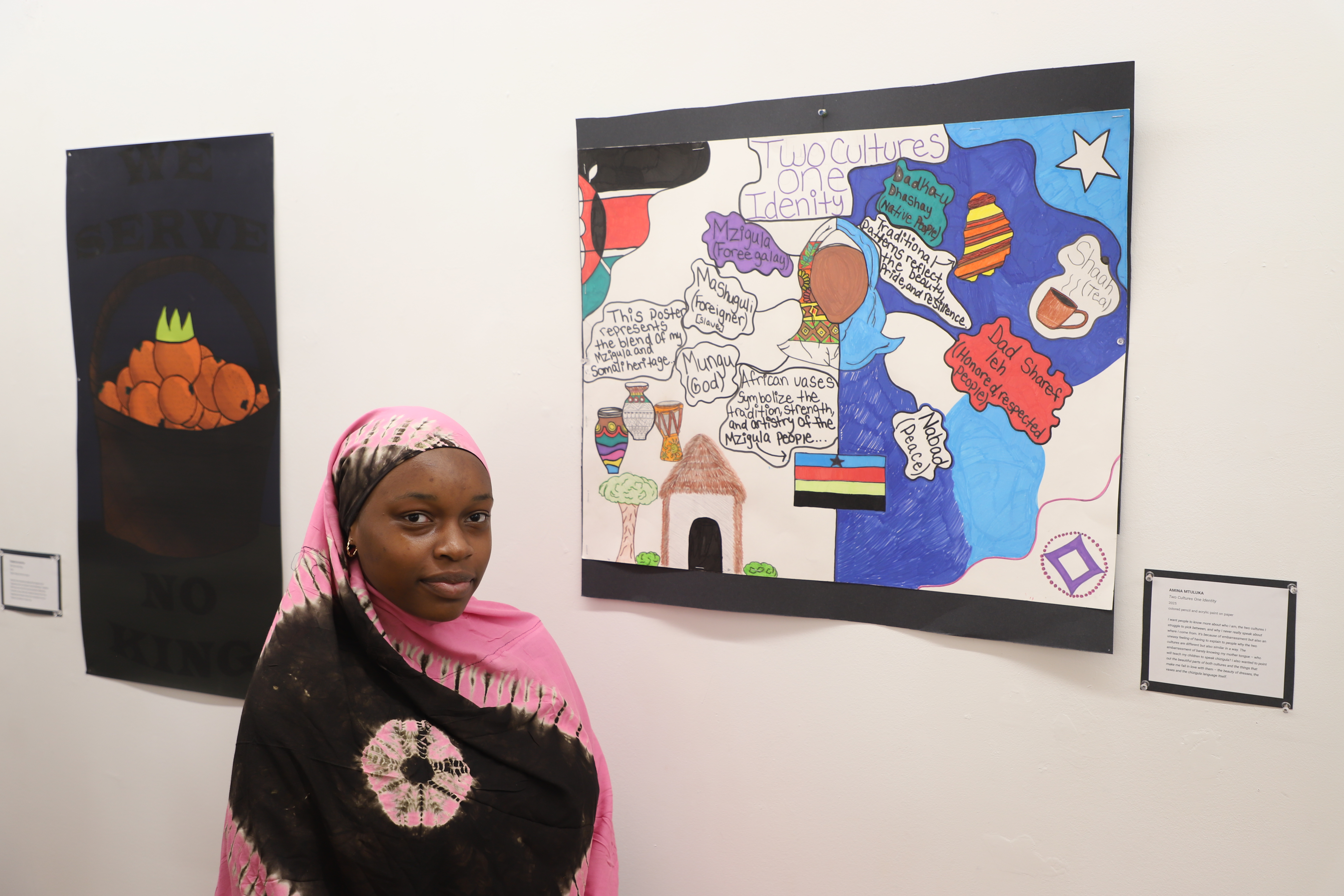 LEAP student, Amina, standing next to a marker drawing she created