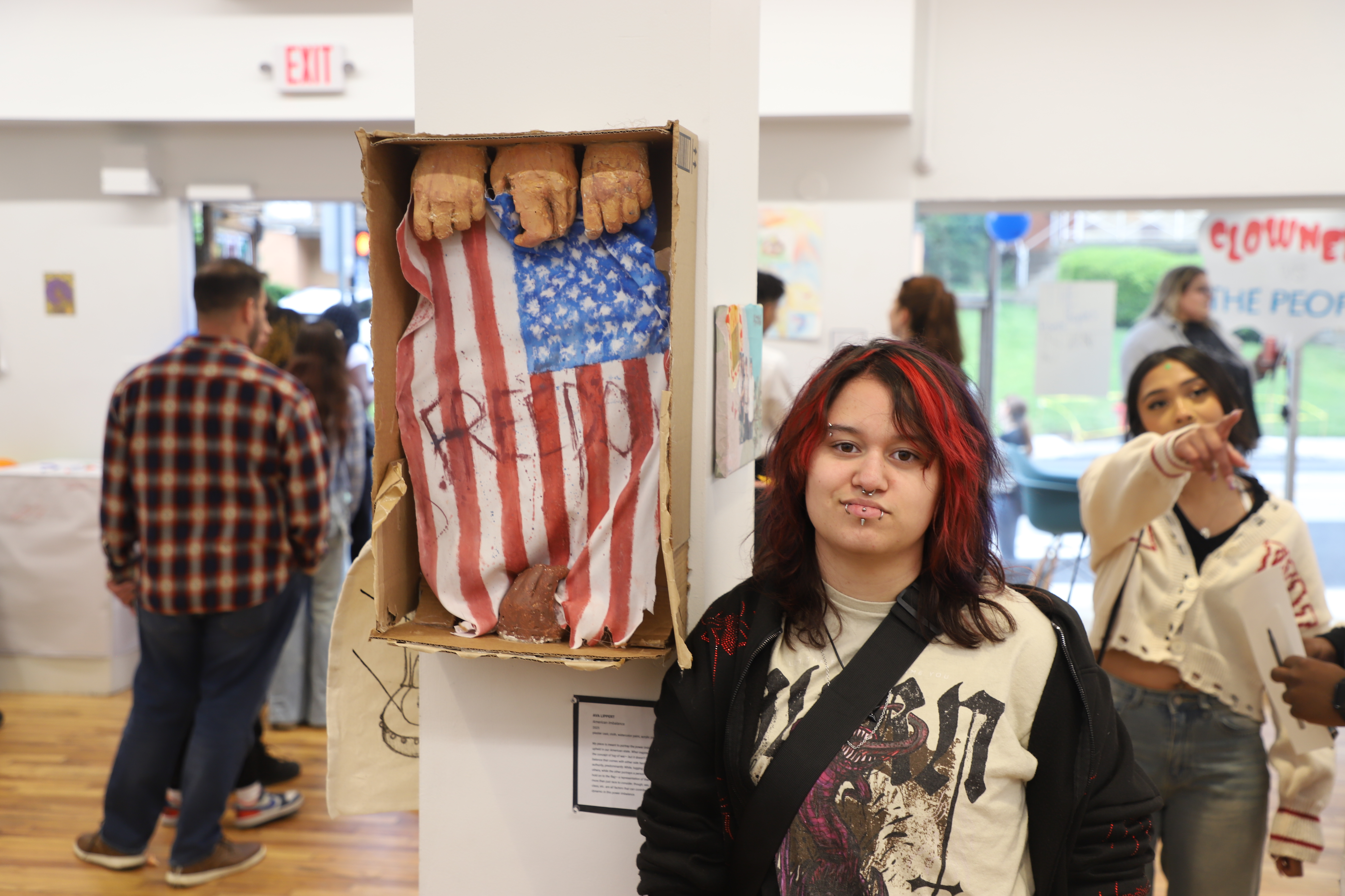 LEAP student Ava standing next to a mixed media sculpture they created