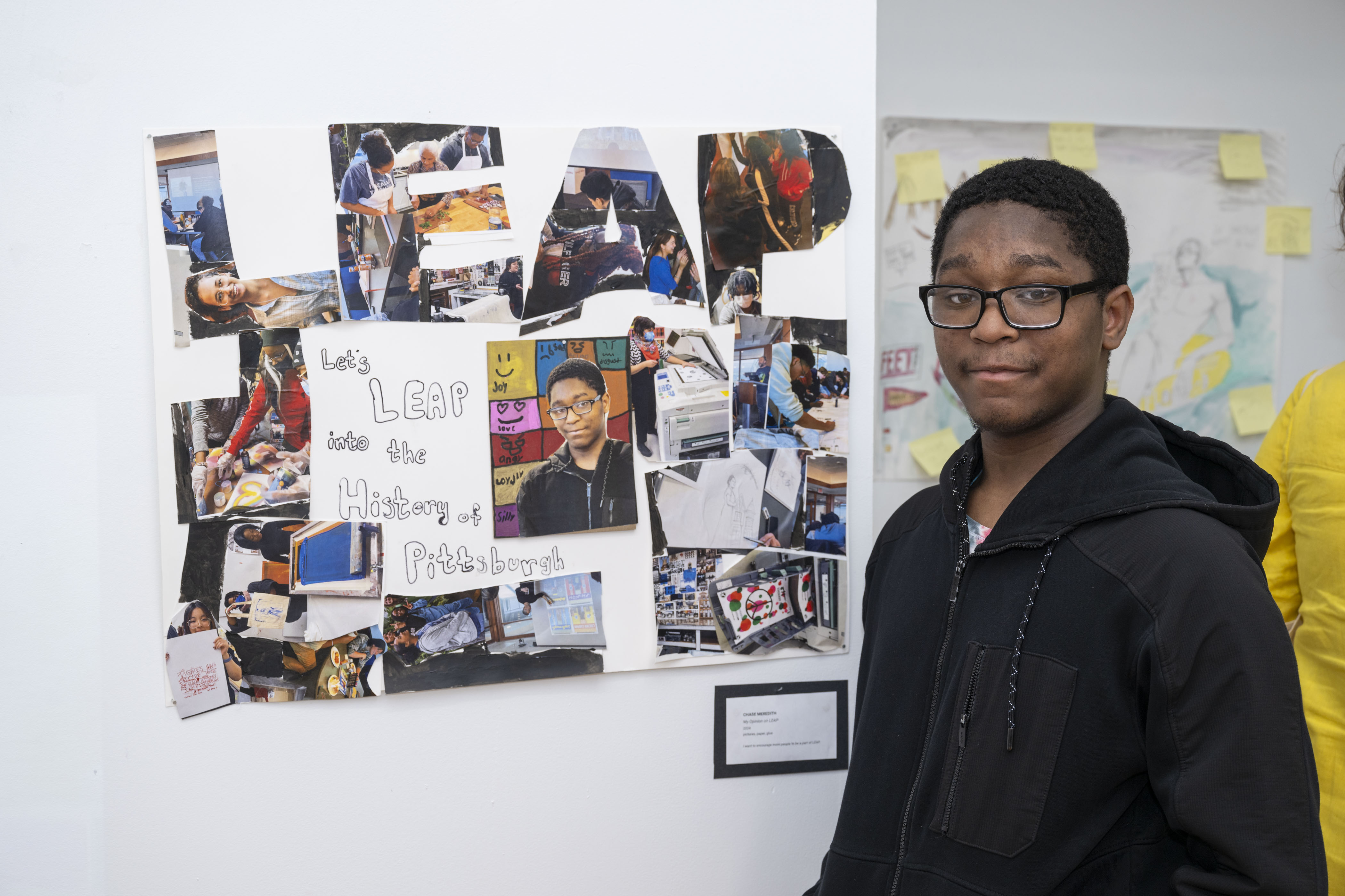 LEAP student, Chase, standing next to a collage he created