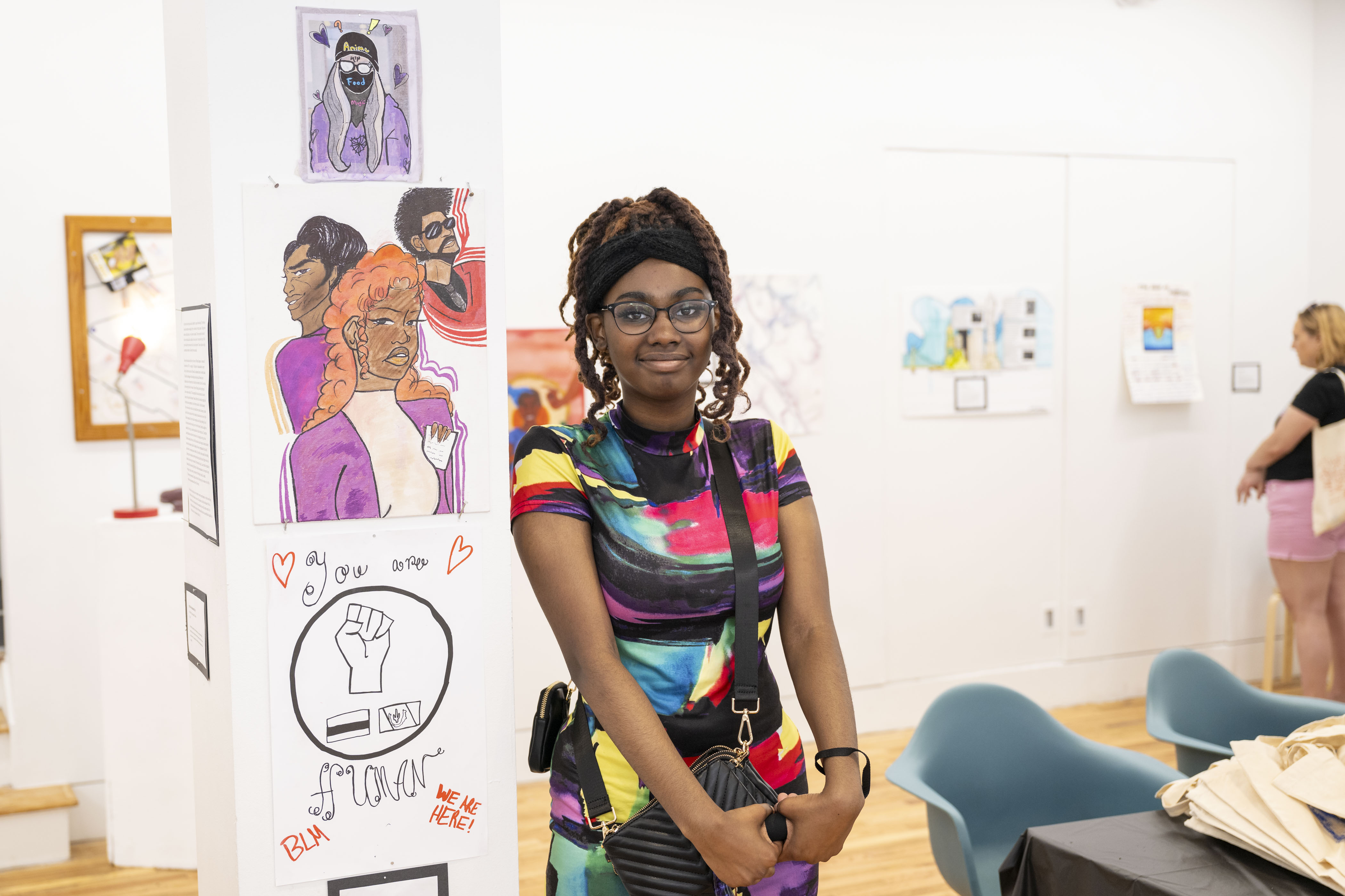 LEAP student, De'Nejah, standing next to a drawing she created and colored with markers