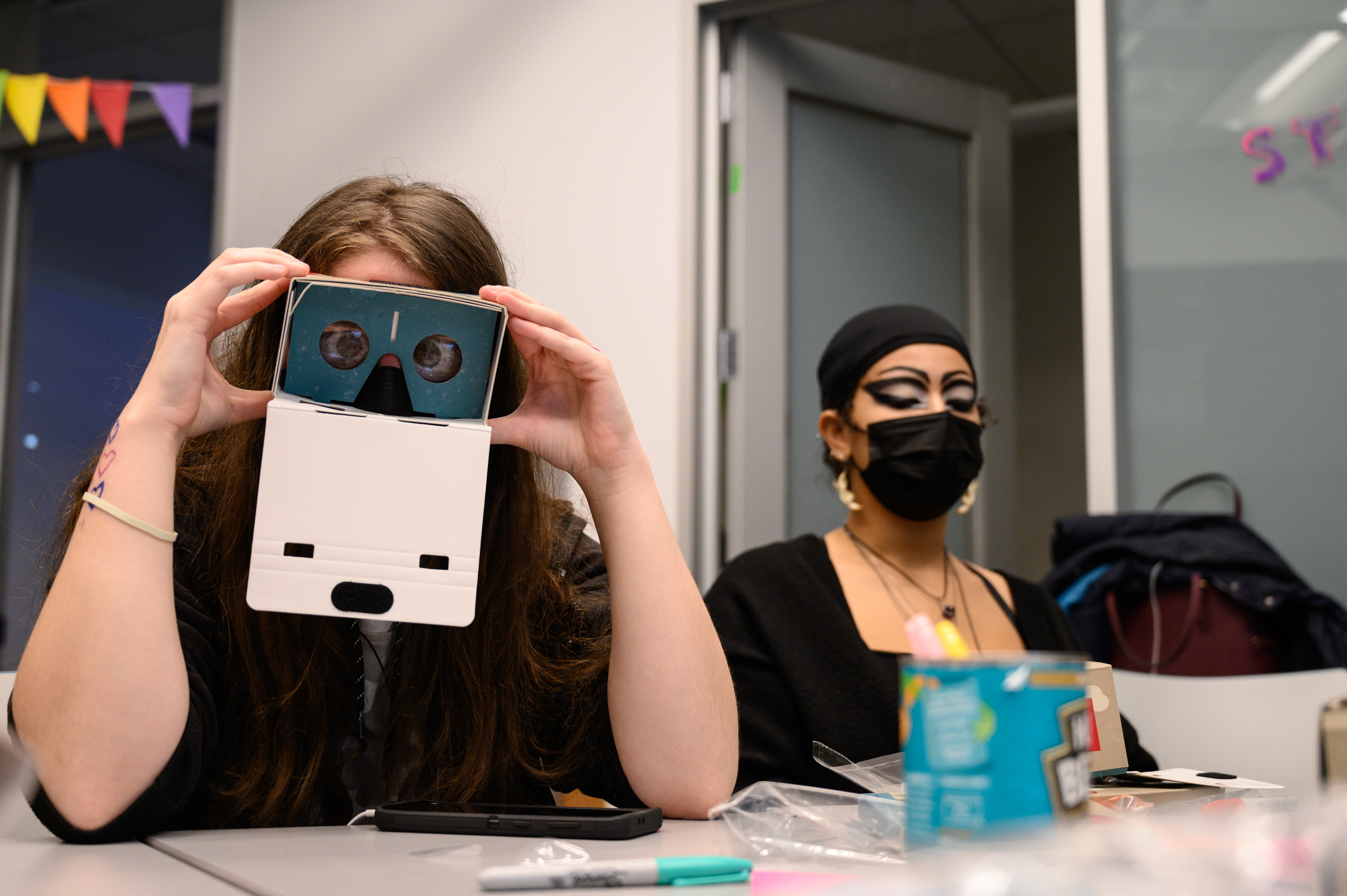 LEAP student holding a cardboard VR headset up to their face