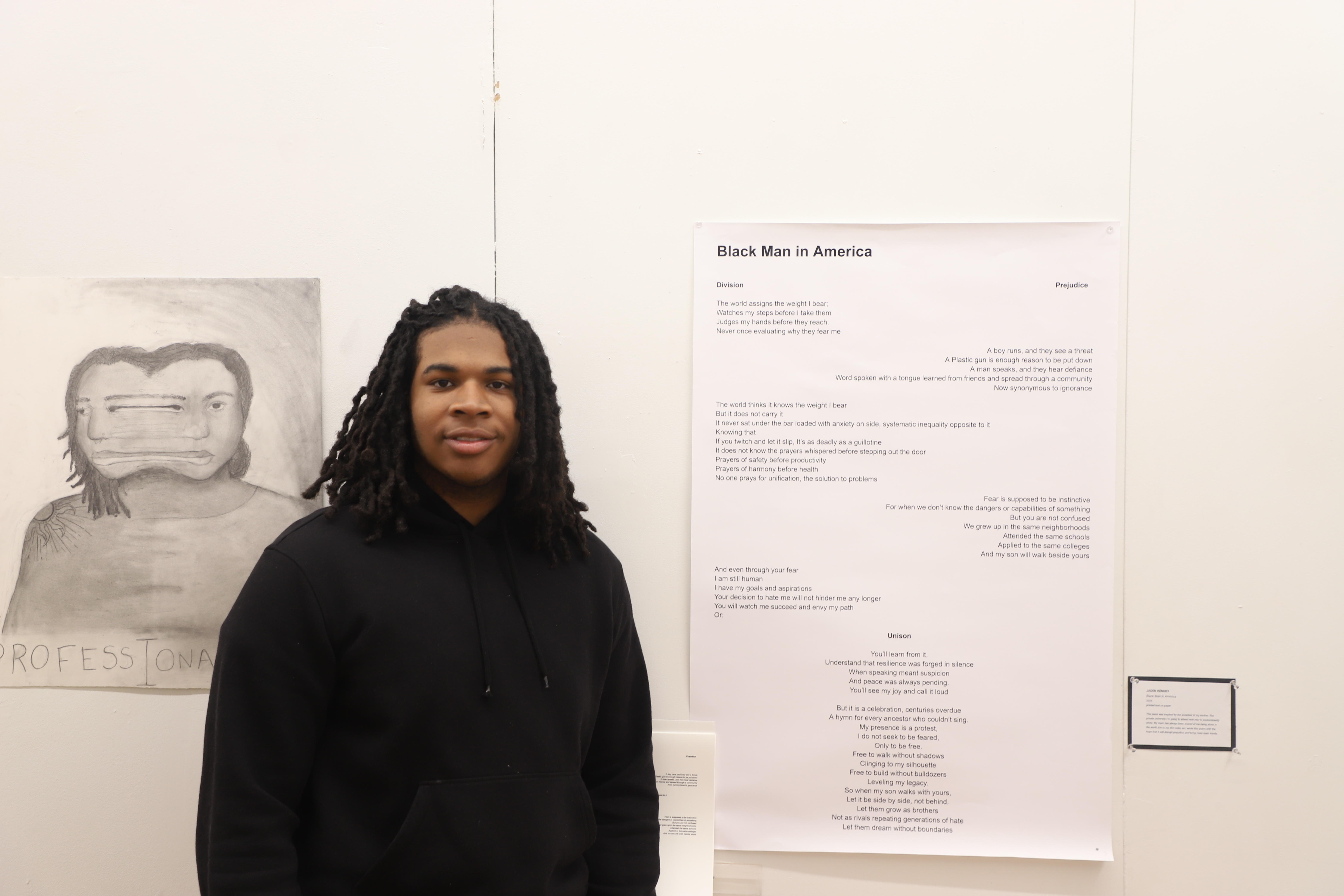 LEAP student Jaden K standing next to a poem he wrote