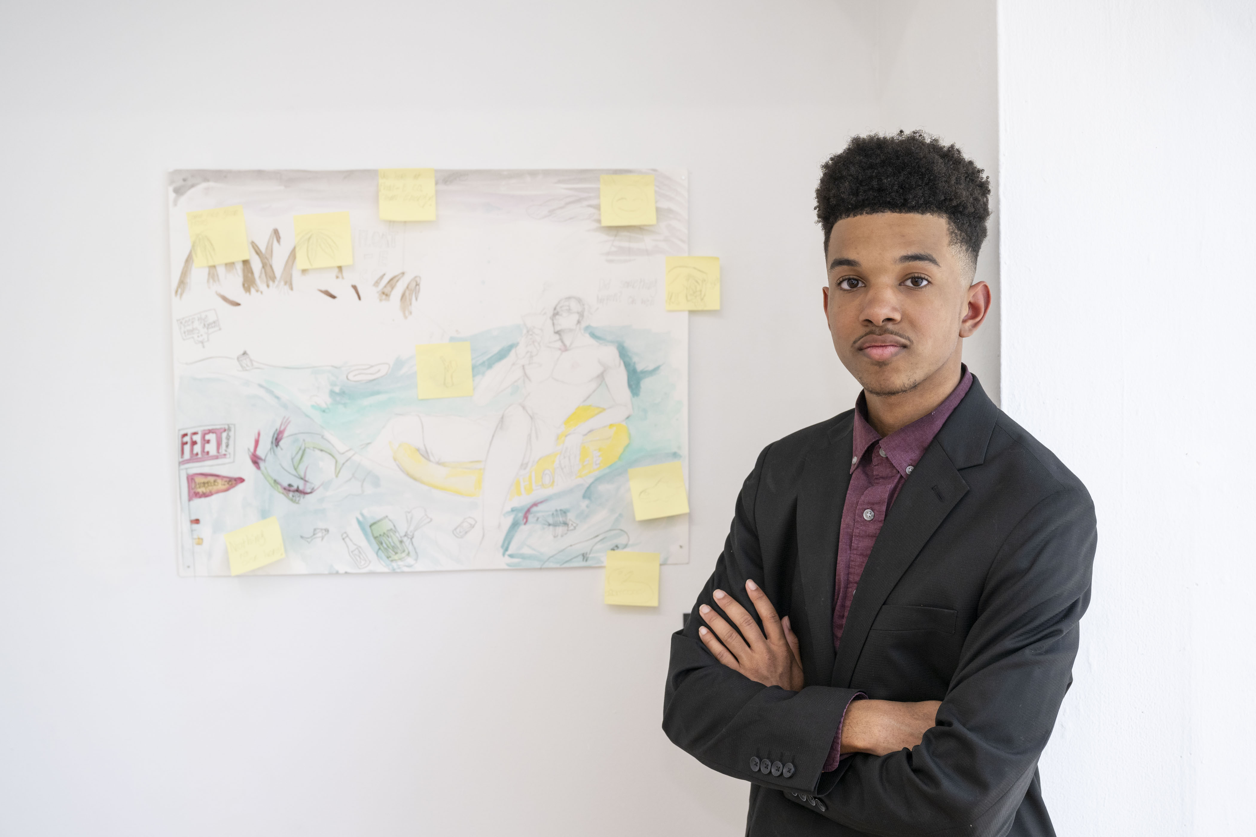 LEAP student Jaden S standing next to a drawing with watercolor accents he created