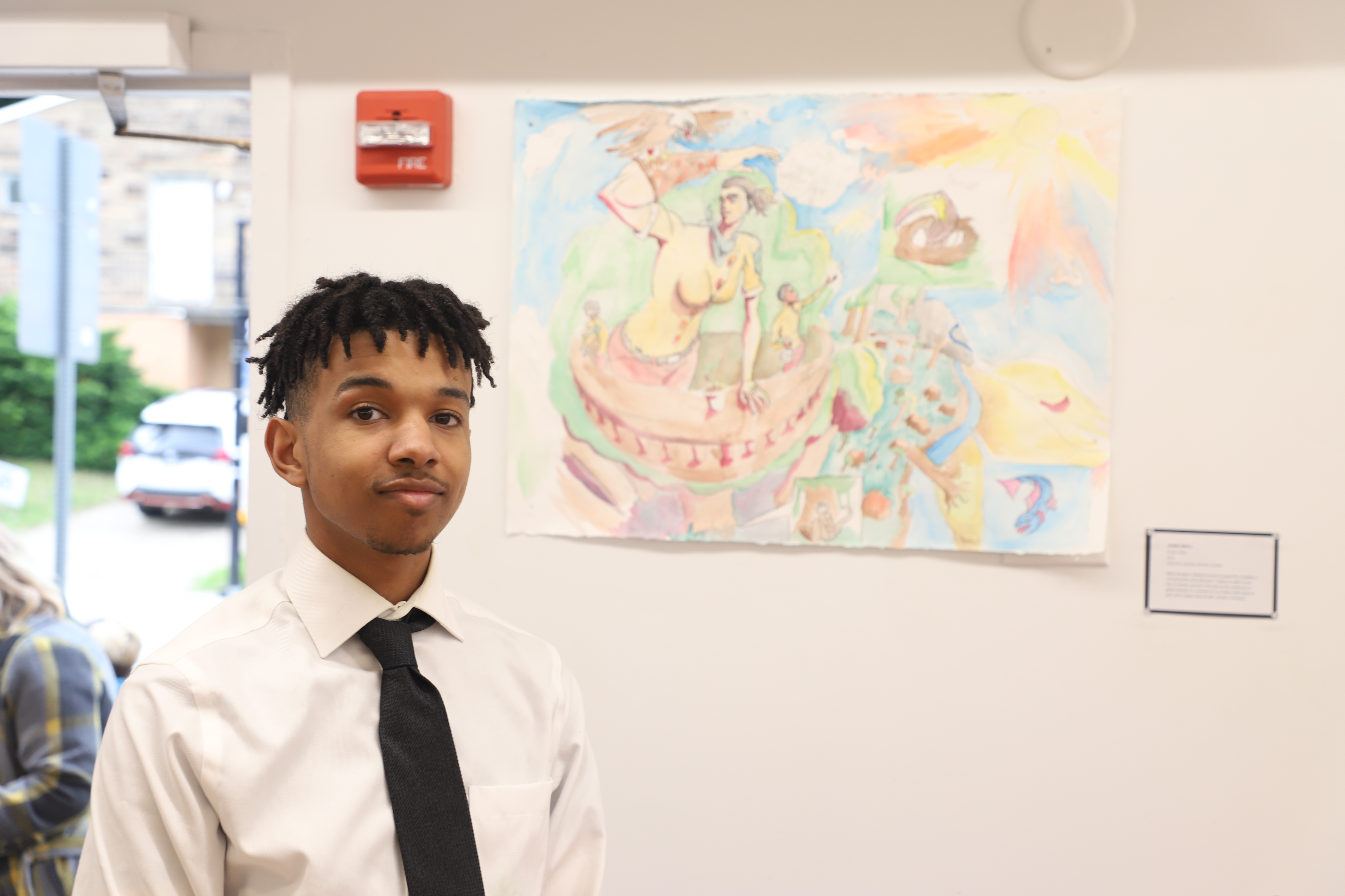 LEAP student Jaden S standing next to a watercolor painting he created