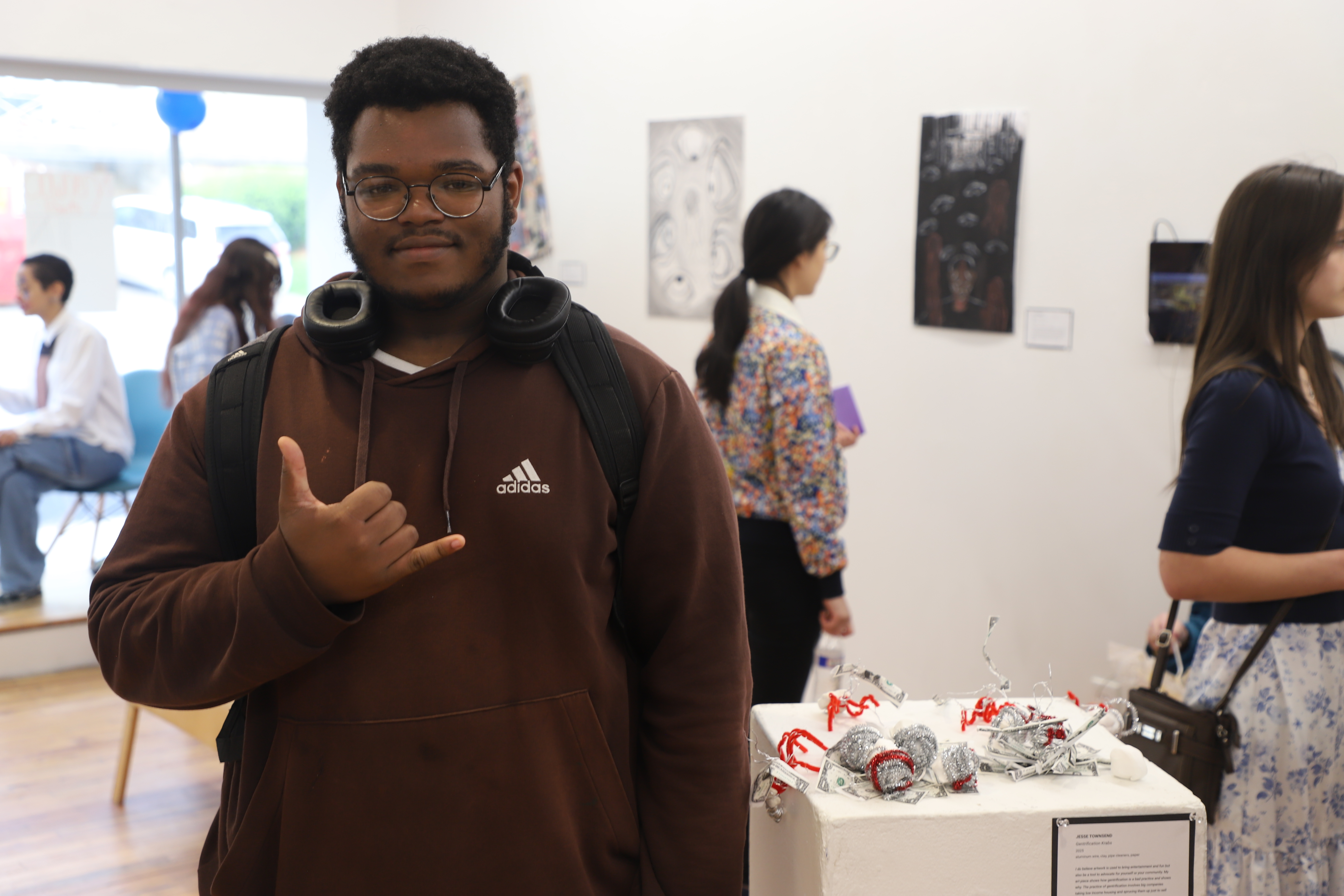 LEAP student Jesse standing next to sculptures he made