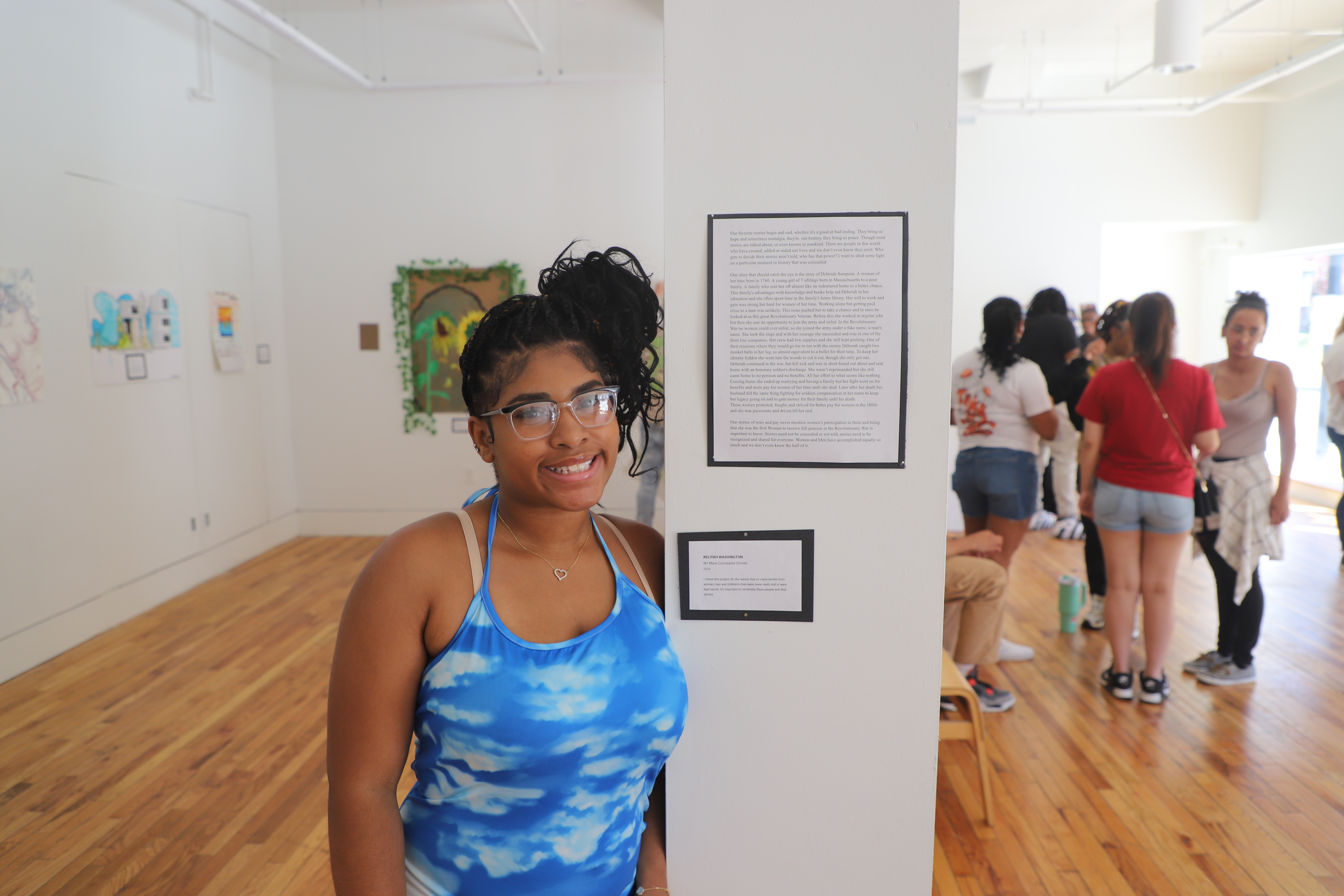 LEAP student, Keliyah, standing next to a short essay that she wrote