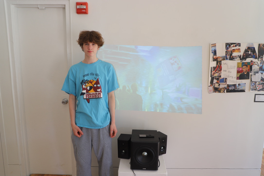 LEAP student, Maks, standing next to a projection of a digital image he created