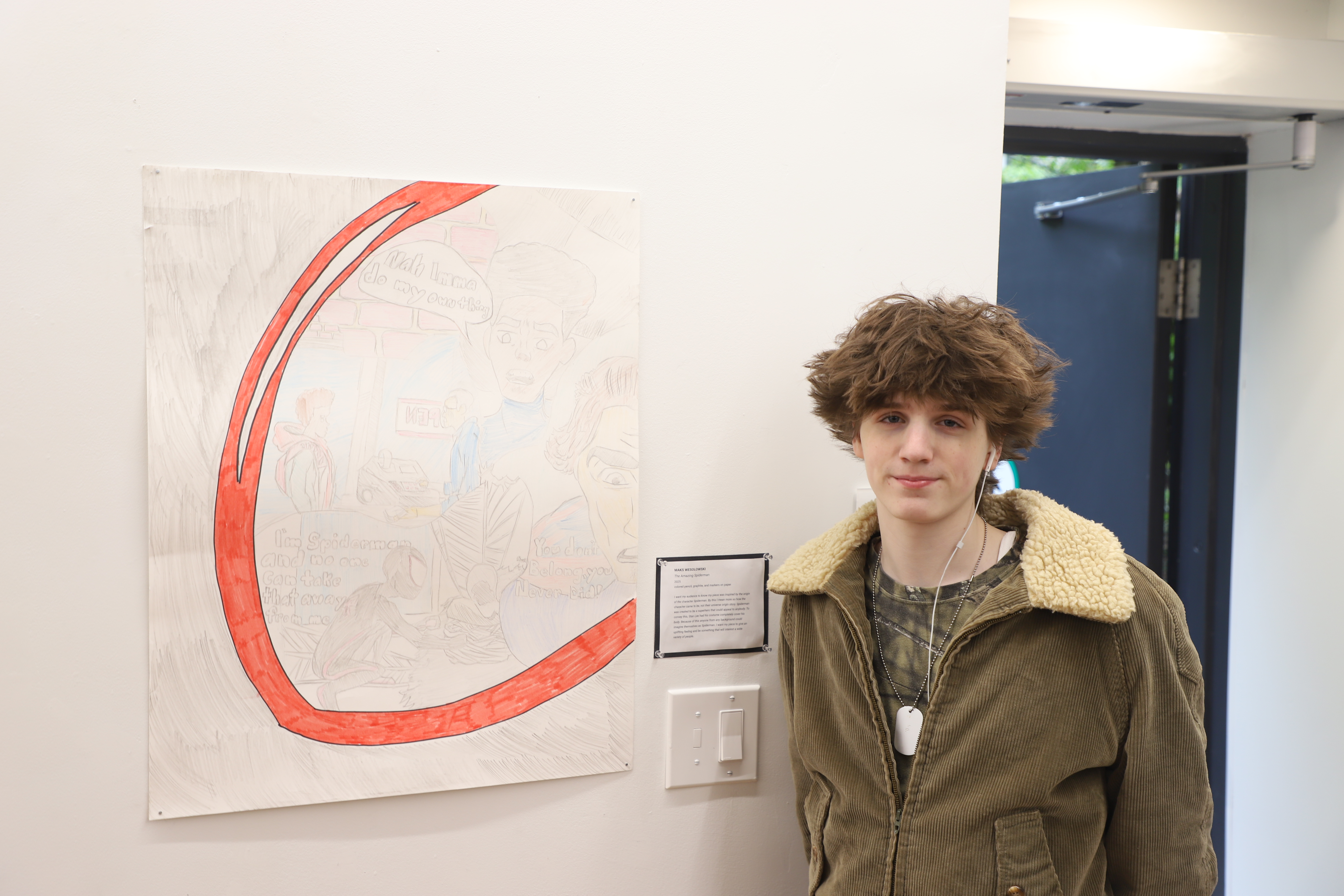 LEAP student Maks standing next to a drawing he created