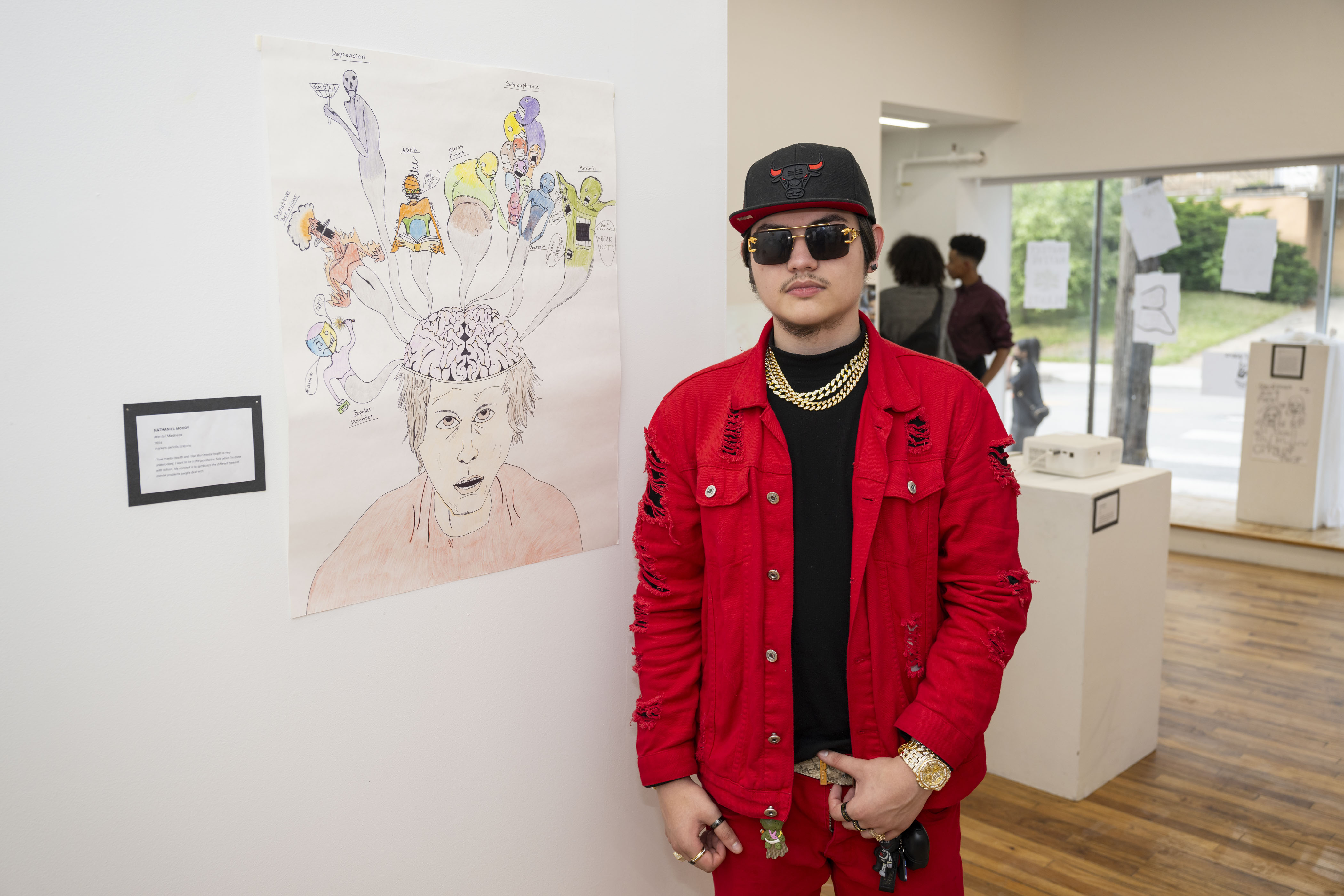 LEAP student, Nate, standing next to a drawing he created