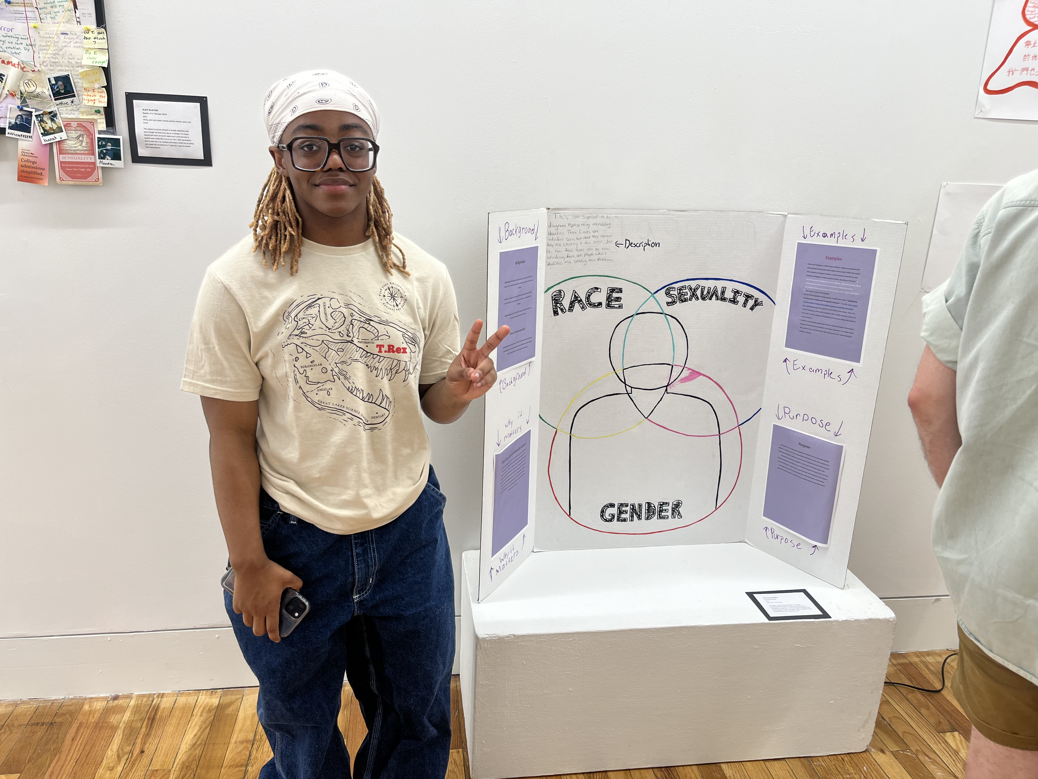 LEAP student, Rae'Von, standing next to a trifold board with drawings and printed text that he created