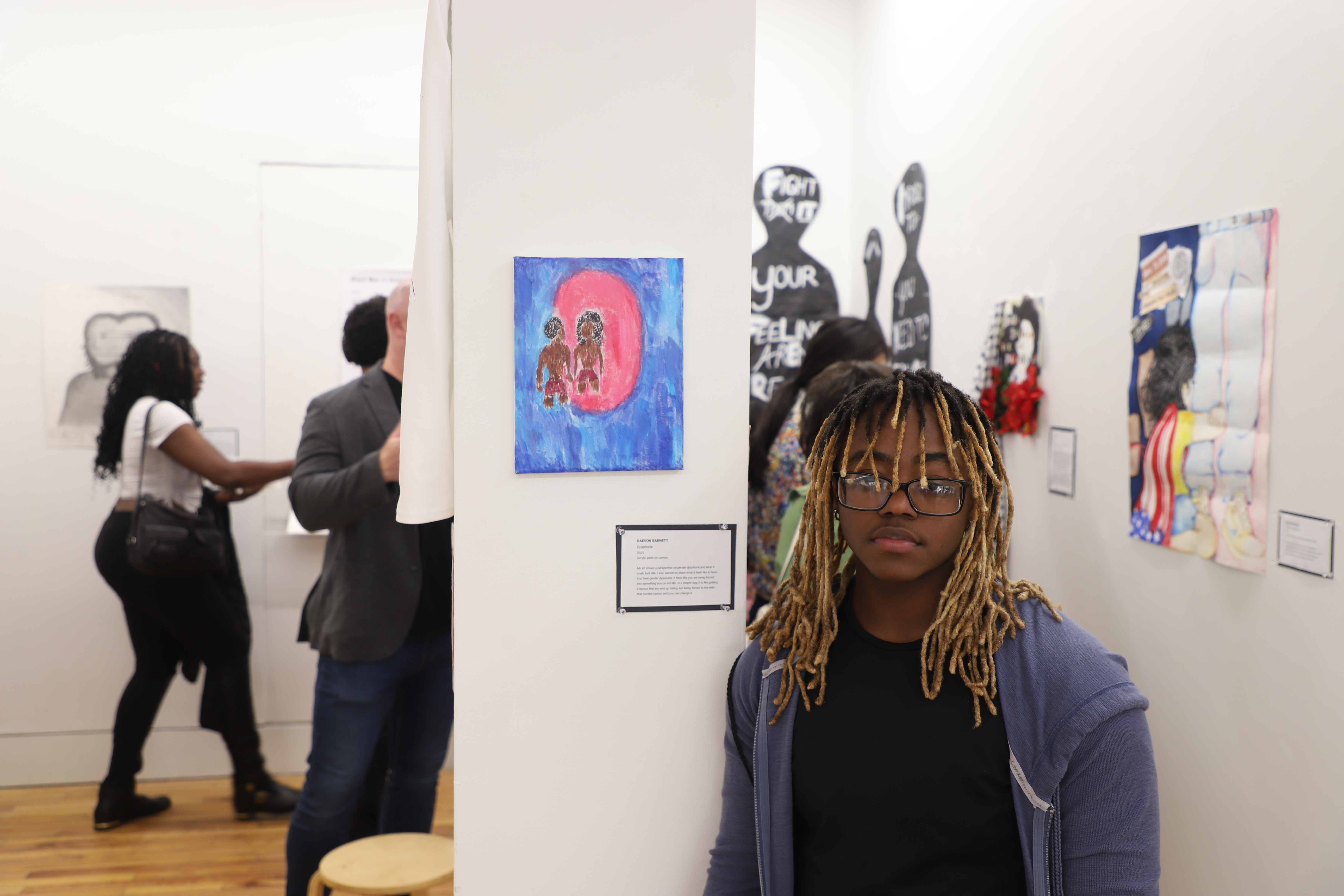 LEAP student RaeVon standing next to a painting he made