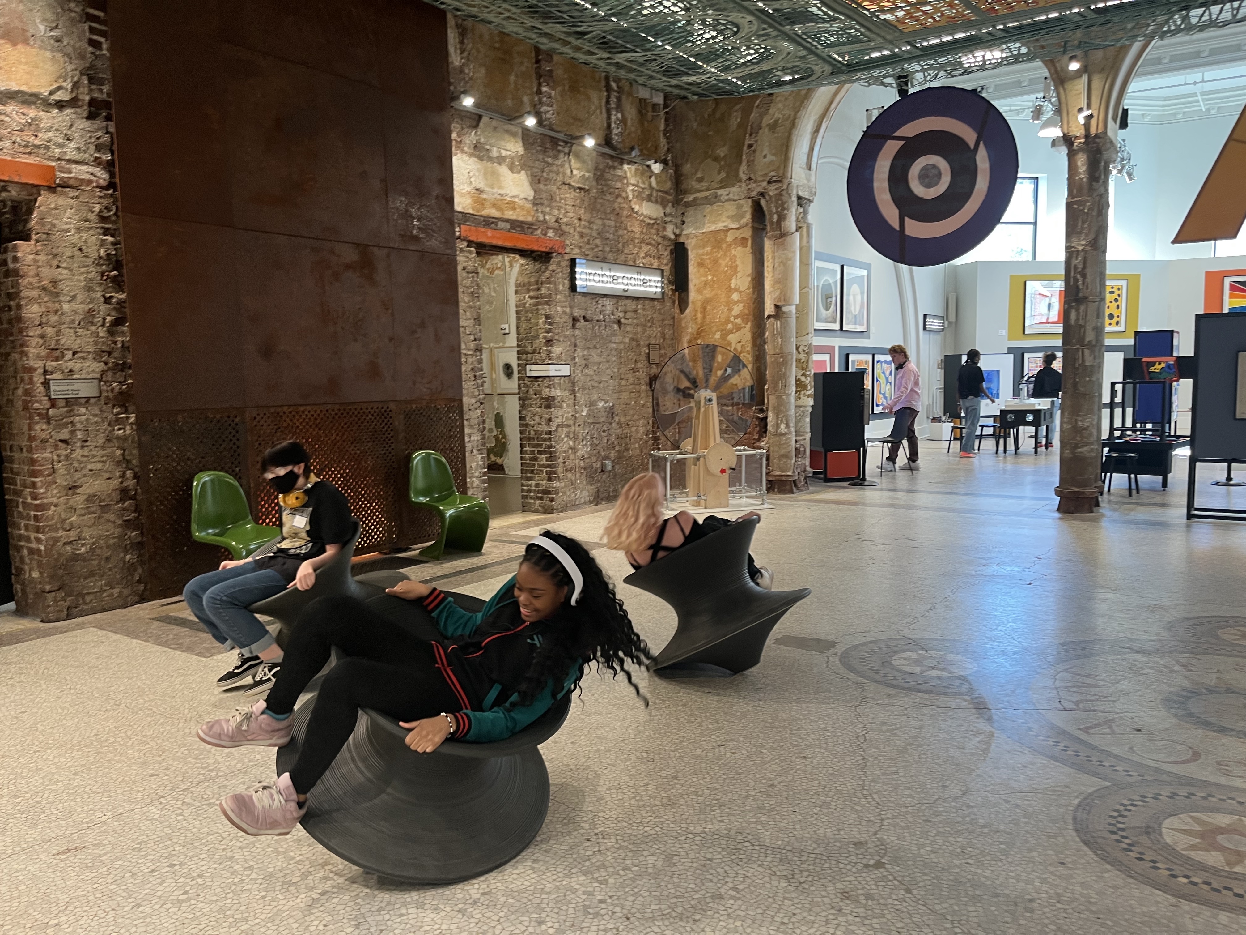 Students laughing as they swivel on spun chairs in MuseumLab