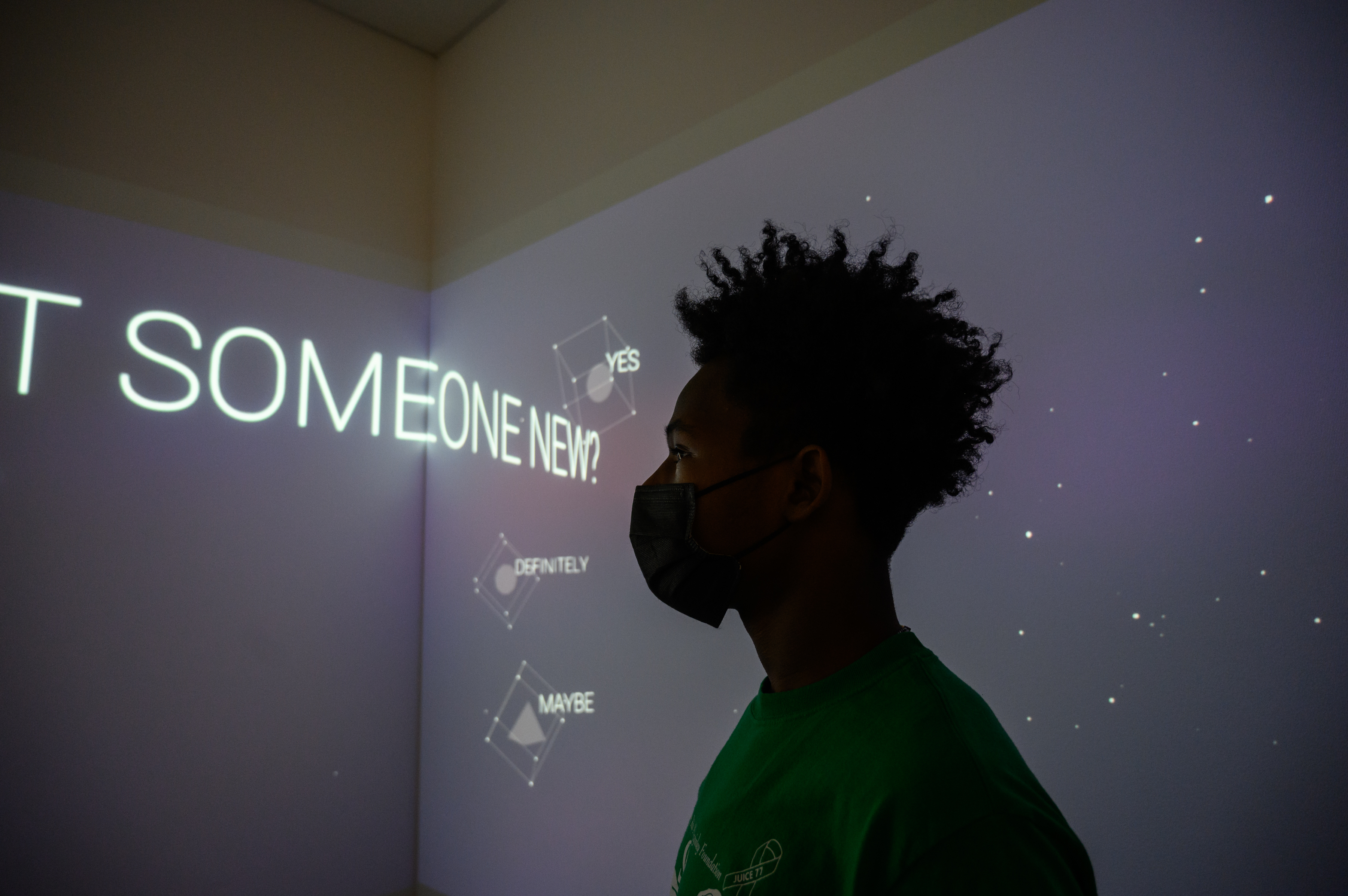 LEAP student, Brandon, silhouetted against a room with projections