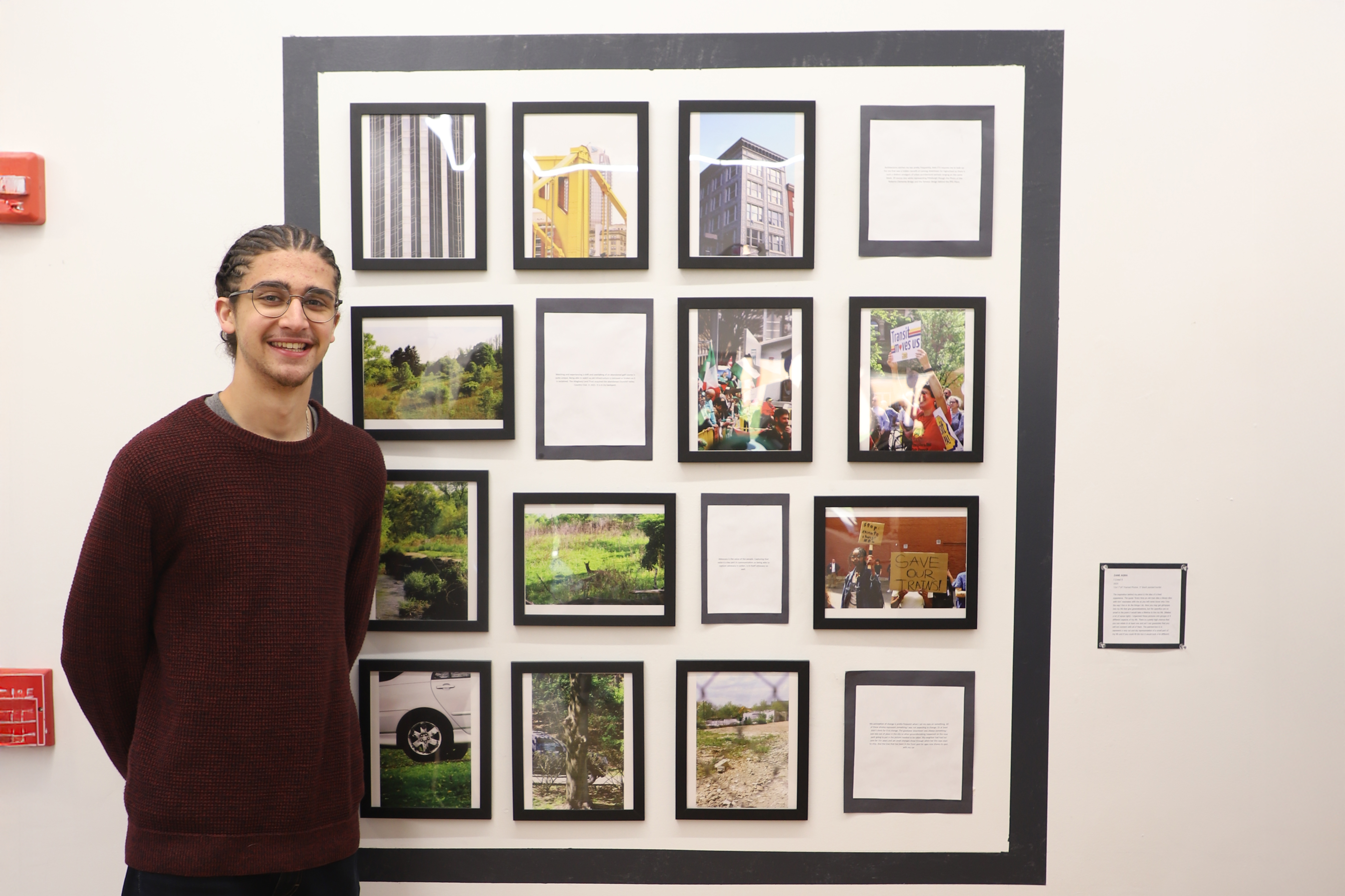 LEAP student Zane standing next to a series of photographs he took