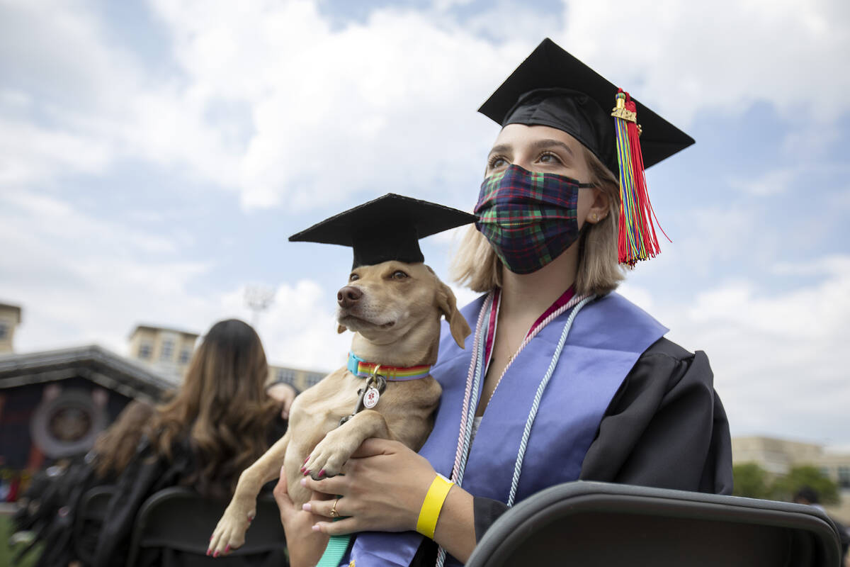 Student and dog wearing graduation caps