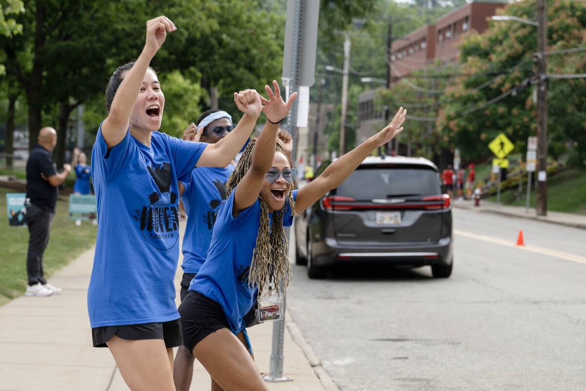 Students cheer along a street.