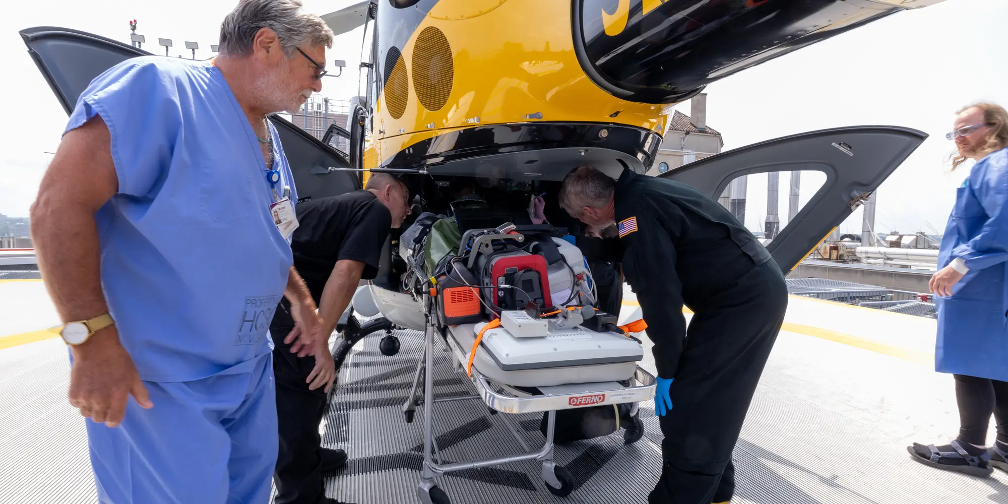 People load things into a helicopter.