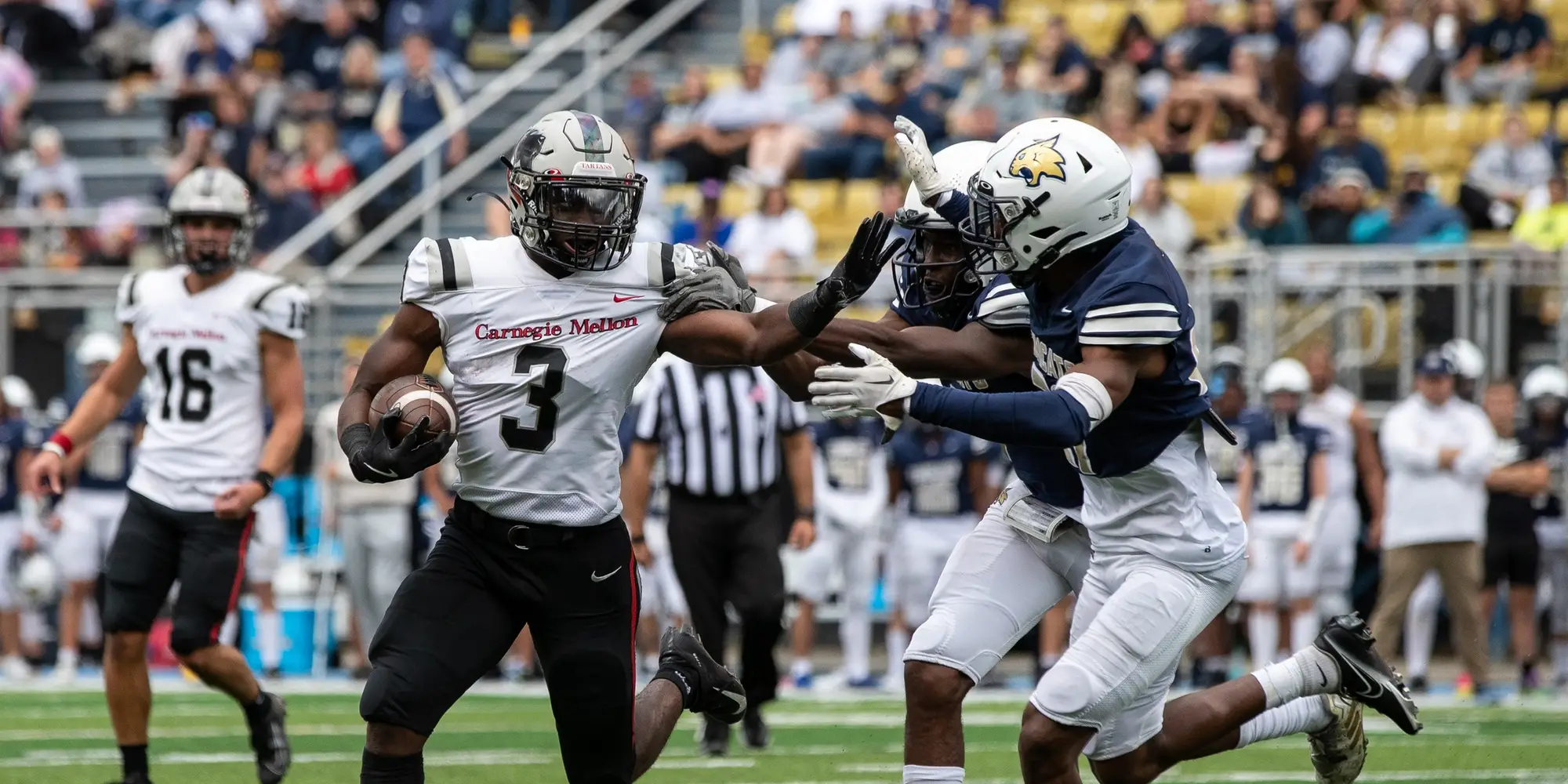 A running back in football pushes back against defenders.