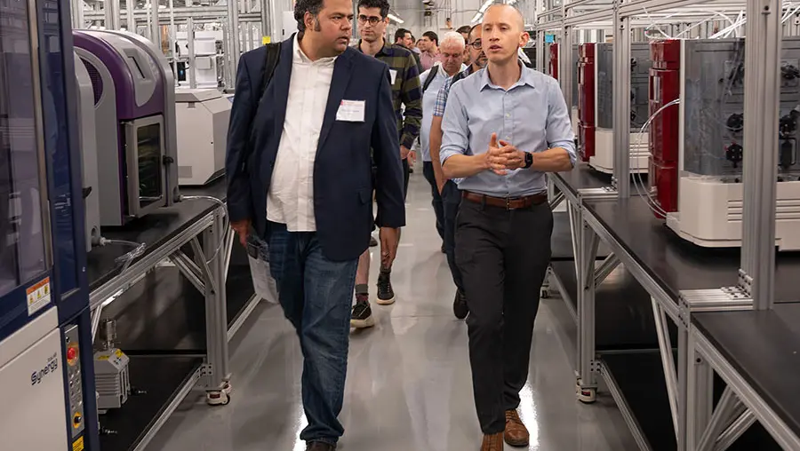 Two people walking between machinery