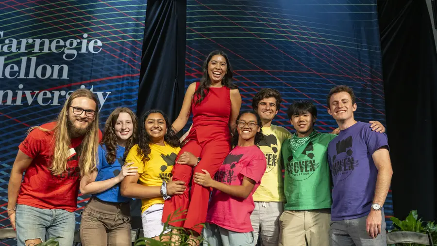 Orientation counselors pose for a group photo, lifting up fellow head counselor and event emcee Elizabeth Zapanta.