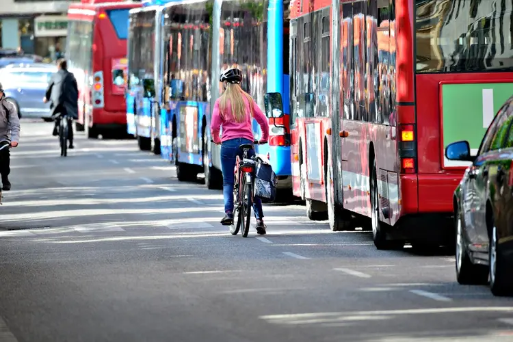 A bicyclist and a bus in traffic