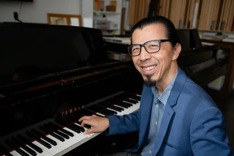 Frederic Chiu seated at Yamaha piano smiling