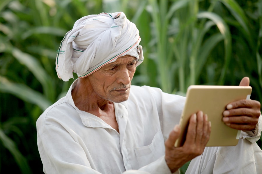 A rural farmer in India looks at an iPad