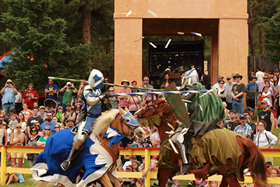 Image of two people in armor on horseback, jousting 