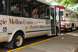 Image of two CMU busses on the curb