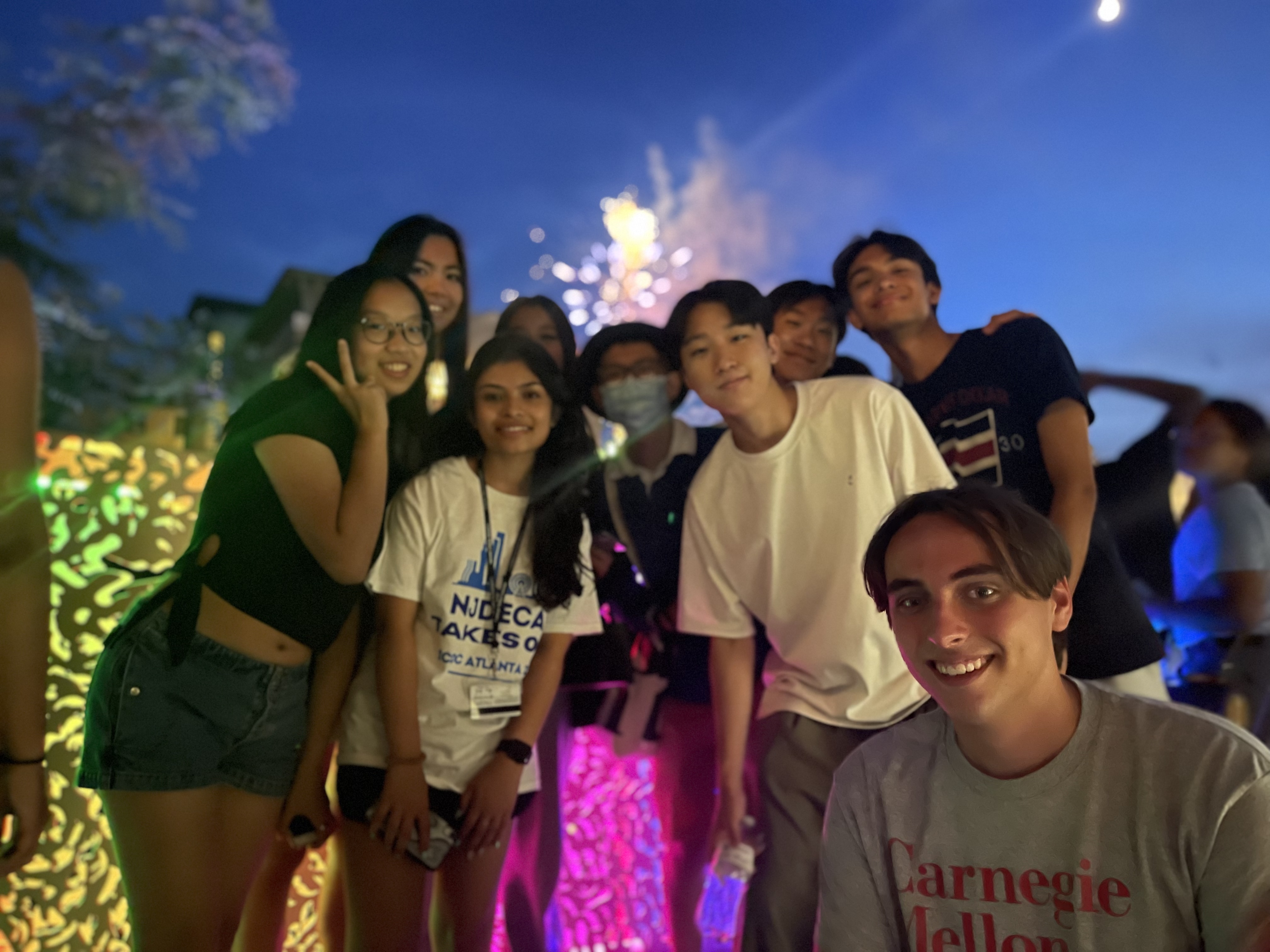 Pre-College students with fireworks behind them. 
