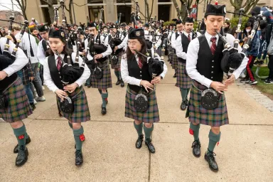 From left: Elizabeth Knox, Alexandra Knox and Roy Huang at the front of the CMU Pipes and Drums band at Spring Carnival opening on April 7, 2022.