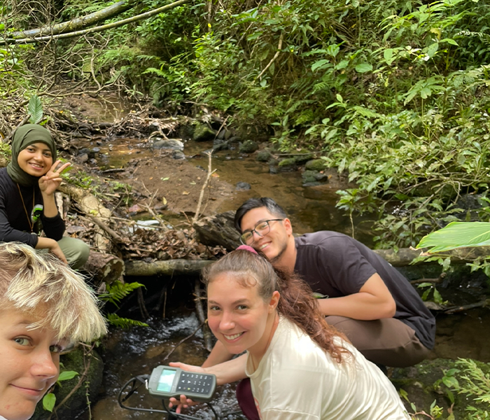 photo of five students conducting research in a stream in Costa Rica