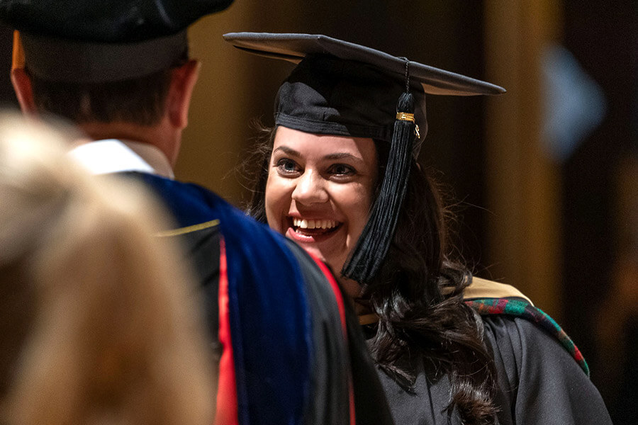 A female MBA student receives her diploma from the dean.