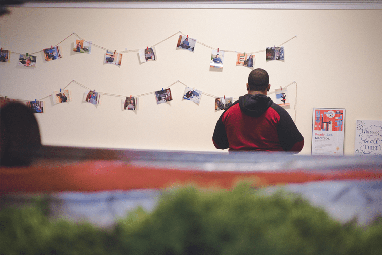 Student checks out hanging photos and art in Mindfulness Room Art Gallery