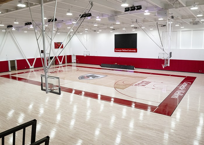 a large gymnasium with shiny floors and the Tartan mascot