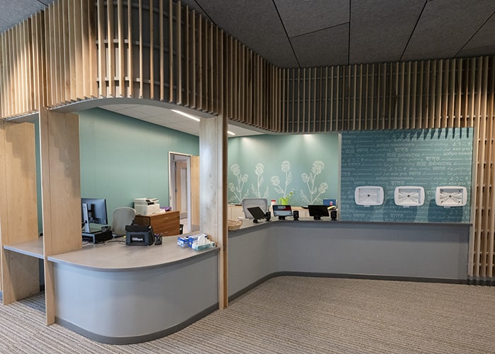 health services lobby with a large reception desk and teal walls