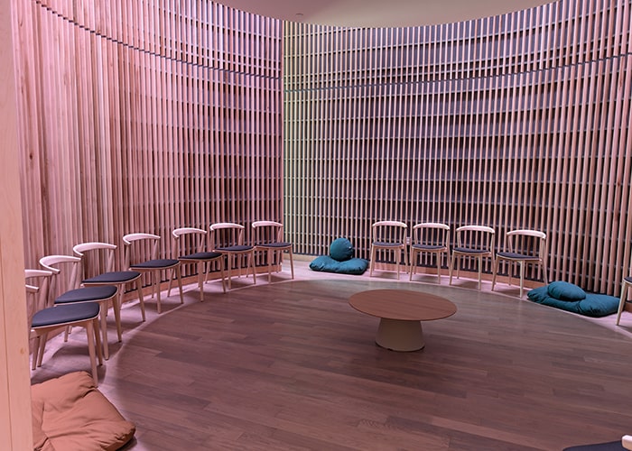 a circular interfaith room will wood panels and a purple glow