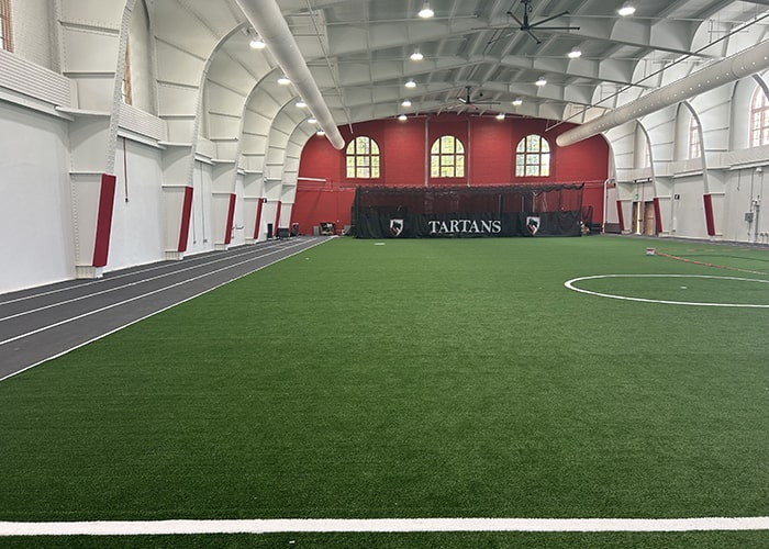 CMU field house with green turf and a track